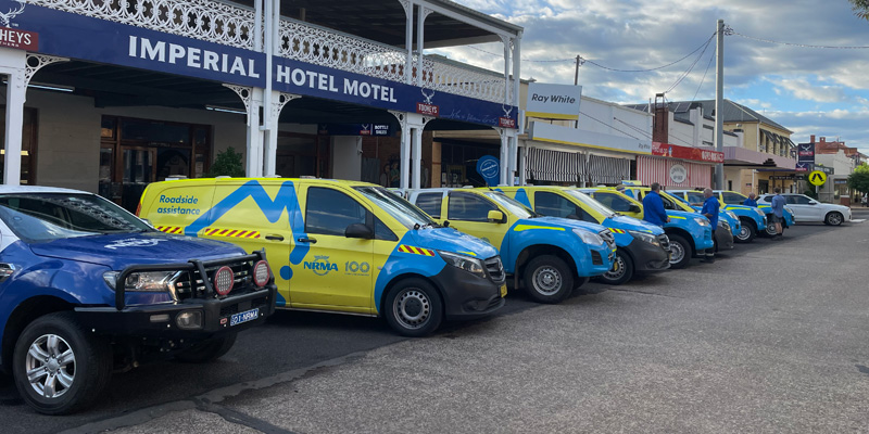 a line of blue and yellow nrma vehicles parked alongside each other