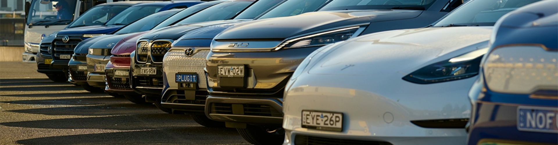 Front view of a row of electric vehicles parked in an angle.