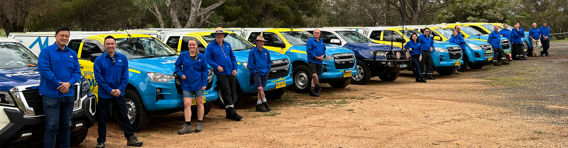 NRMA staff and patrol stand in front of a line of patrol cars