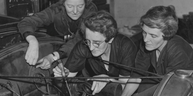 black and white photo 1940s of NRMA women's transport auxiliary lead K Broadbent adding the NRMA transport auxiliary triangular flag to the front of her car windscreen