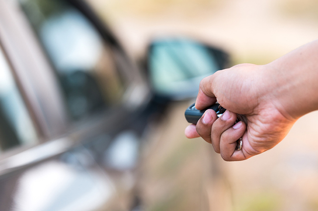 Person using key fob to remotely lock car