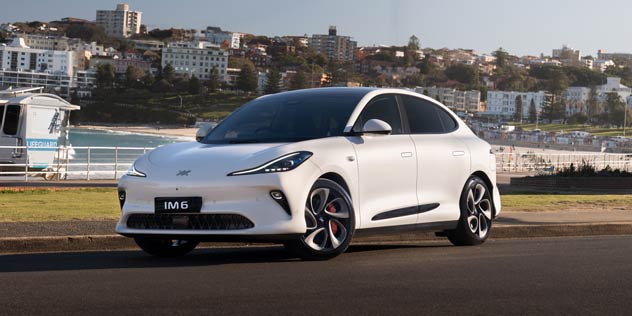 A white IM5 with beach and houses behind