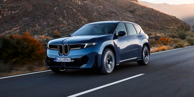 Blue electric SUV on autumn hills road