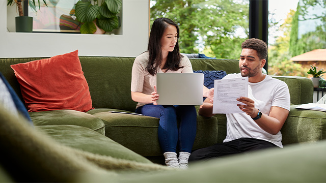 A couple pay bills on the computer
