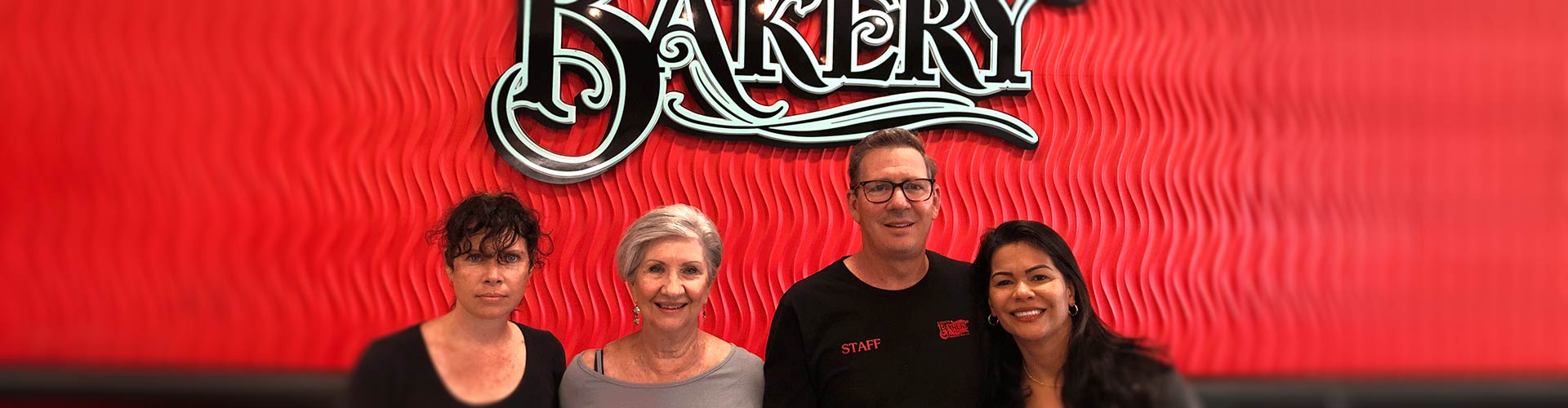 Four people from Barnett's Bakery standing in a row and smiling.