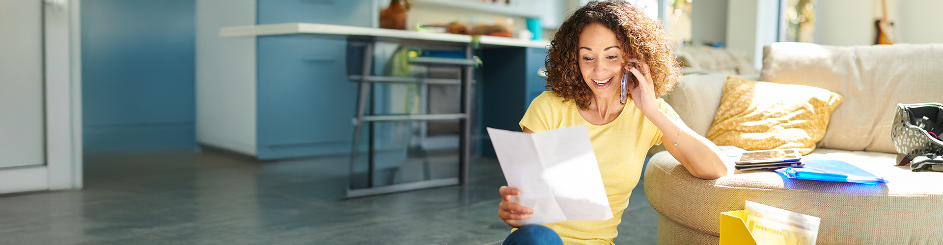 A woman reading a piece of paper and speaking on her phone