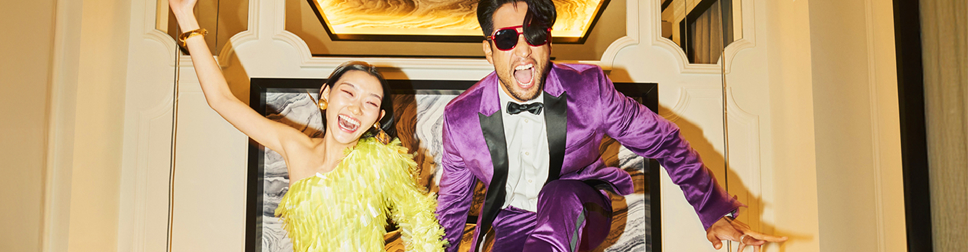 Two people jumping off a hotel bed