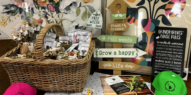 A cute gift basket filled with individually packaged odds and ends on a display table.