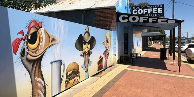 Cute cartoon ostrich murals painted on the side of a cafe wall with a mug, burger and slice of cake.