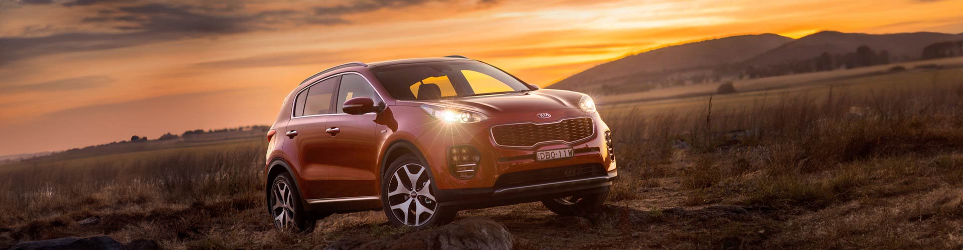 2016 Kia Sportage parked on rocky field at sunset