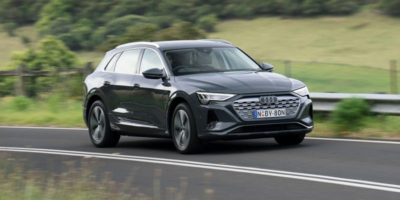 A 2024 Audi Q8 55 e-tron quattro driving on a country road