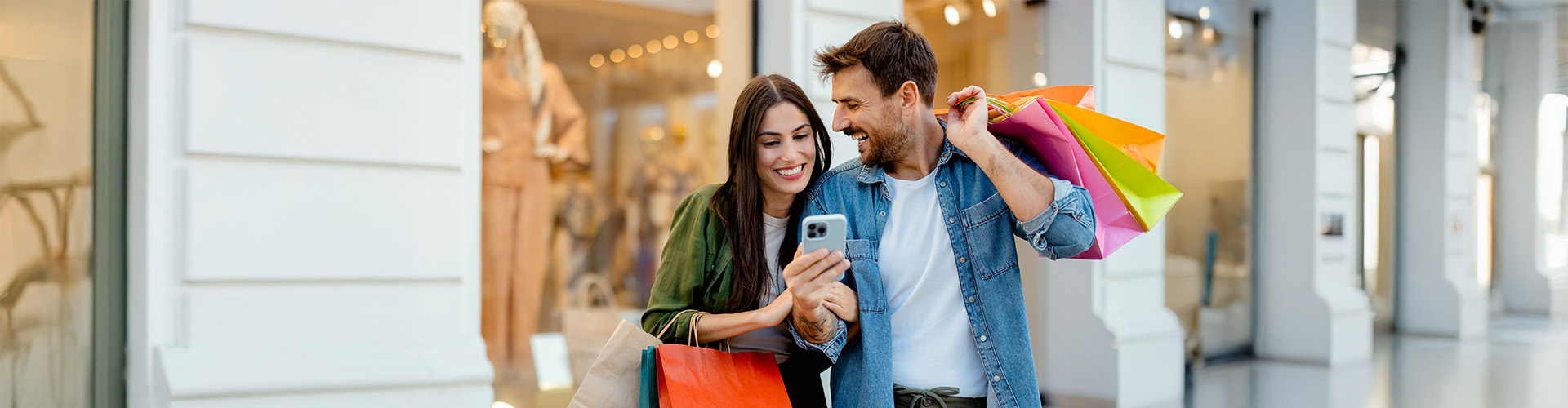 A couple look at a phone outside a shopping centre