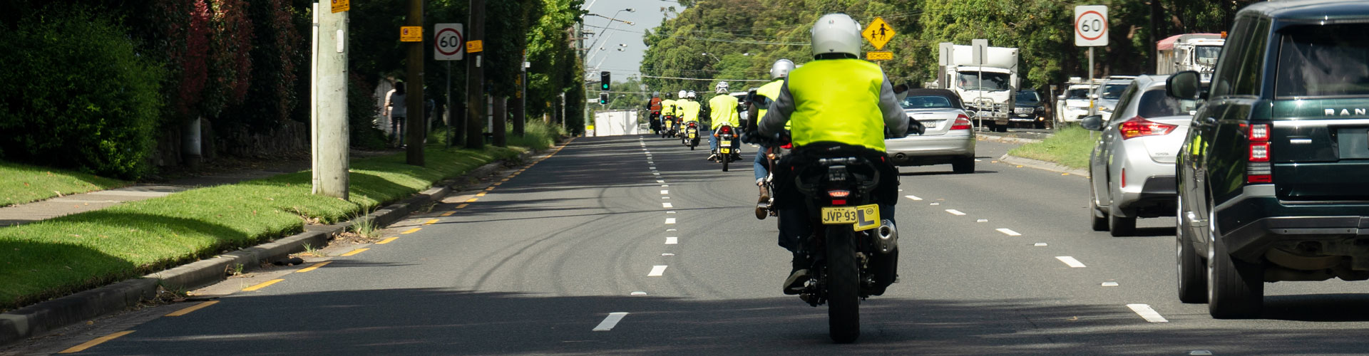 A learner cyclist wearing a hivis jacket on a NSW road