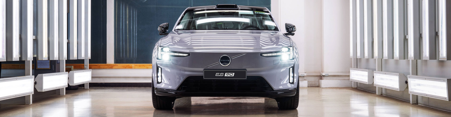 Grey Volvo es90 seen from front parked in garage