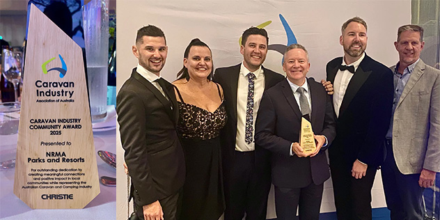 A group of people in formal wear stand with a central person holding an award