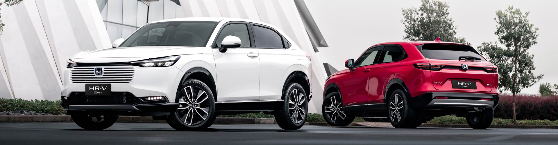 A white and a red Honda HR-V seen from side angle