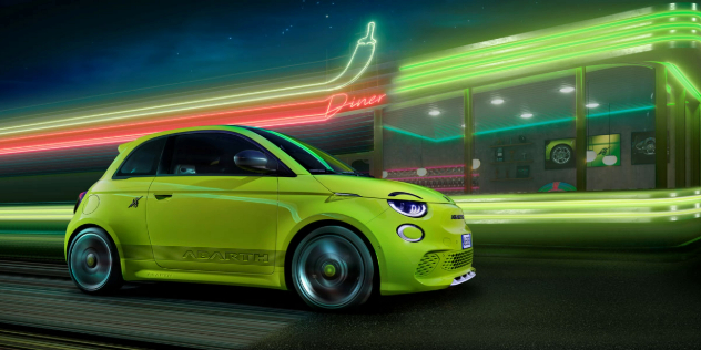 A neon green Abarth 5ooe driving past a brightly lit diner at night.