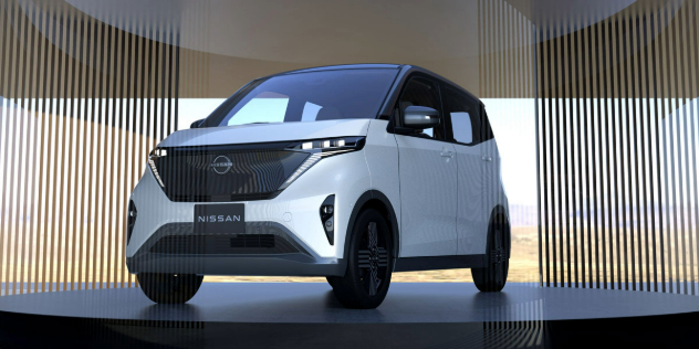 Front angle view of a white Nissan Sakura parked on a round, black showroom-style platform.