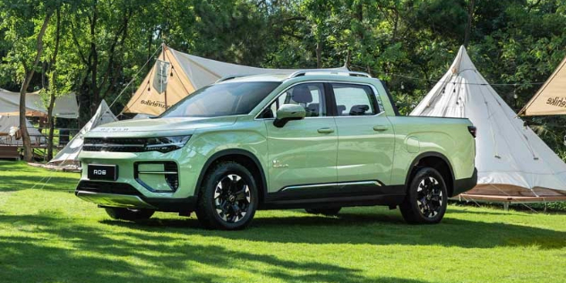 A pale green Riddara RD6 parked at a camping ground amongst tents