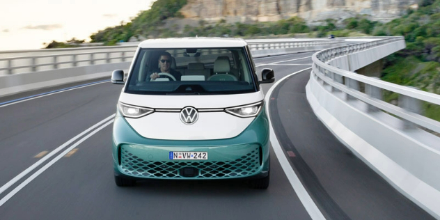 Front view of a green VW ID. Buzz driving along the Great Ocean Road.