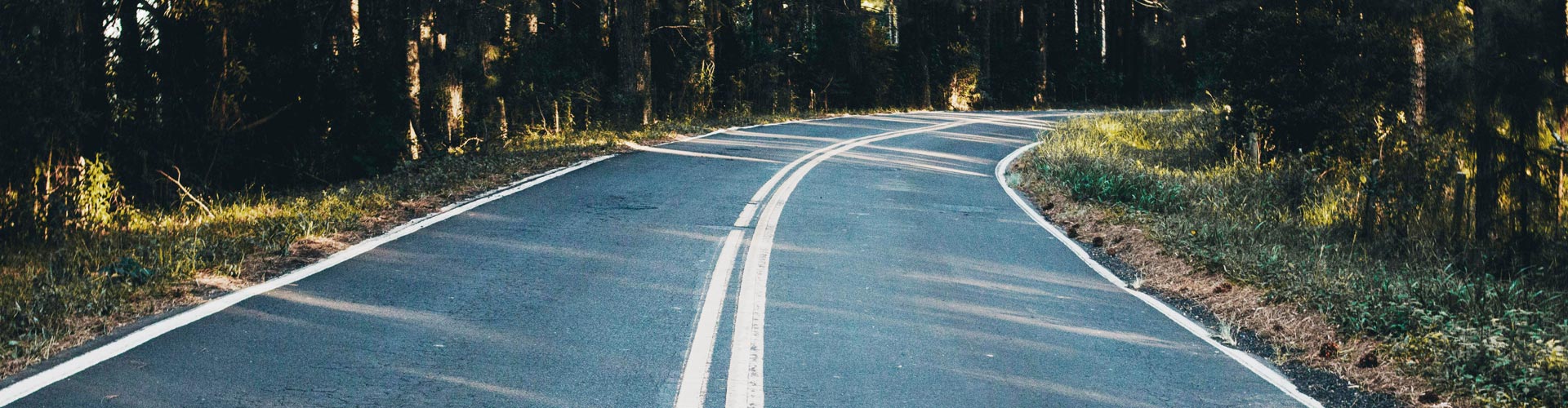 Curved road with double white lines in the centre