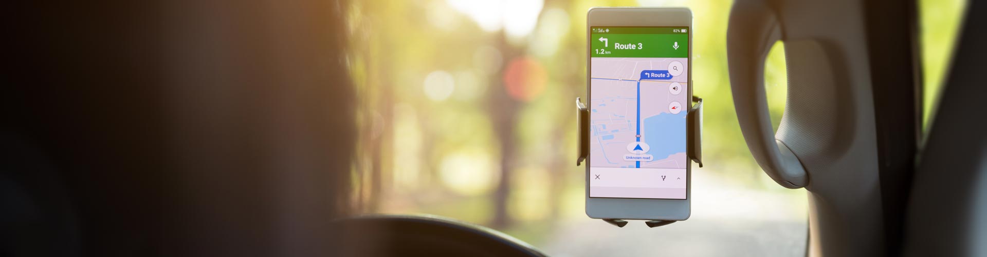 A mobile phone is mounted to the windowscreen of a car