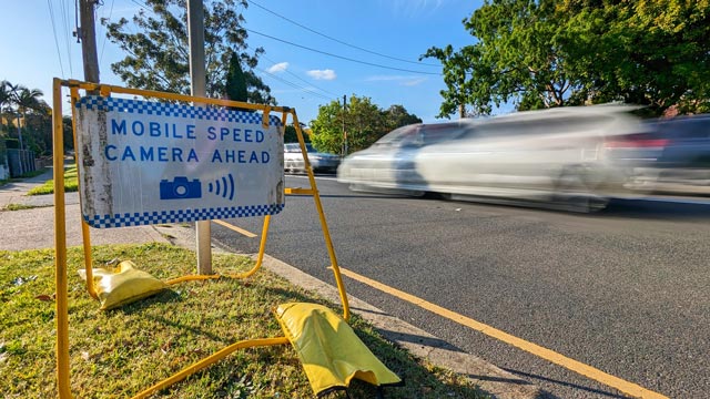 A car speeds past a mobile speed camera