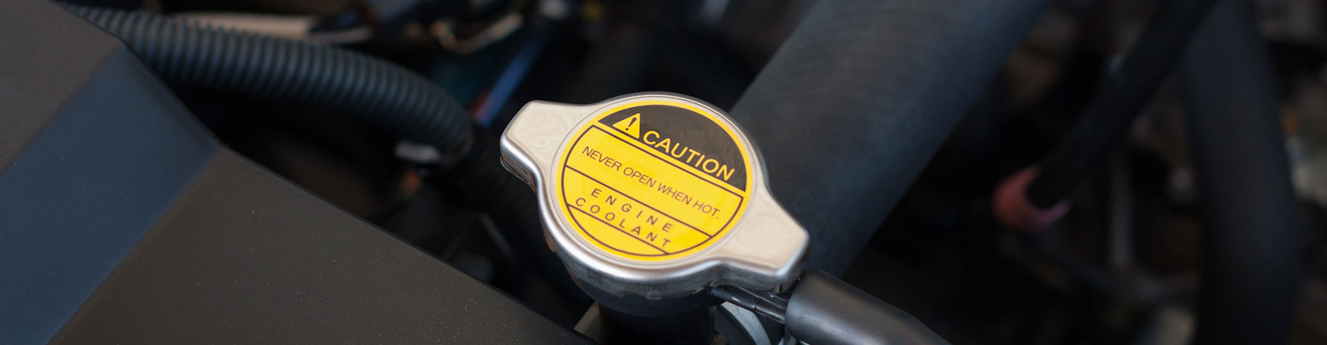 A radiator cap with a yellow sticker on it