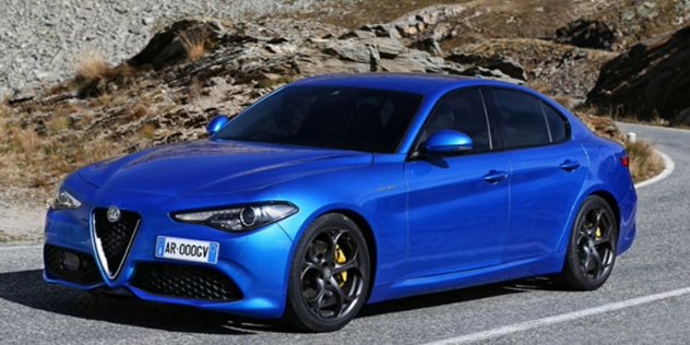 A bright blue Alfa Romeo sedan cornering a bend, with mountains in the backdrop.