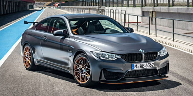 A sporty grey two-door BMW with a yellow accents throughout the car, parked on a track.