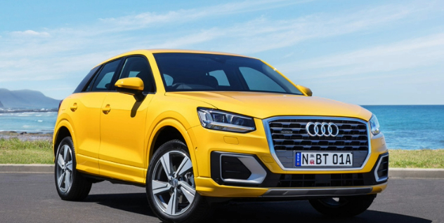 Side angle of a yellow Audi SUV.