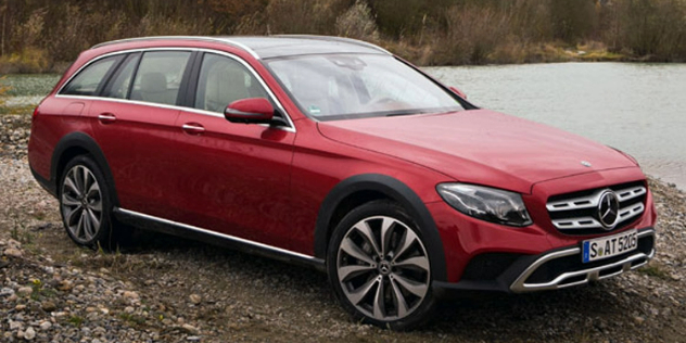 Red Mercedes-Benz station wagon parked alongside a lake.