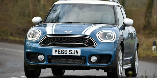 Front view of a blue Mini SUV traveling along a road.