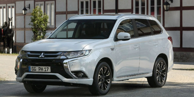 Front-angle view of a white Mitsubishi parked in the shade.