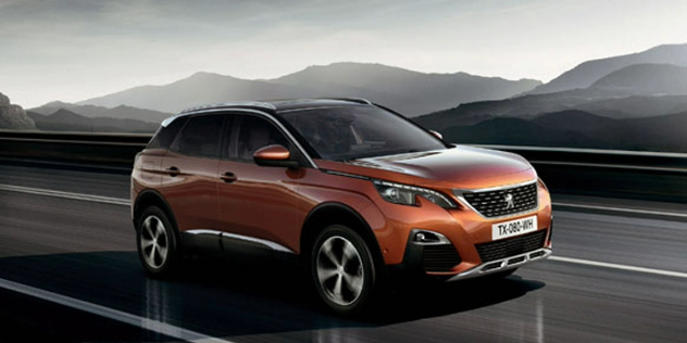 Side-angle view of a rusty orange colour Peugeot travelling along a highway.