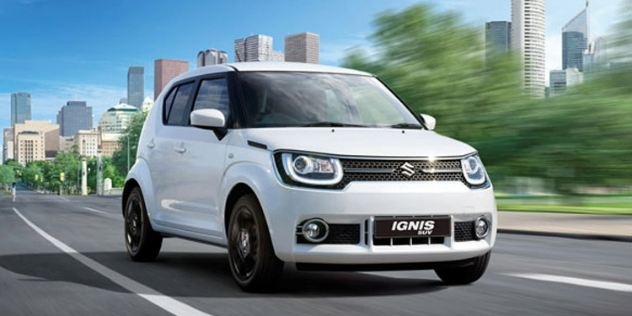 Front view of a small white SUV travelling along a city road.