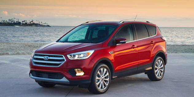 Side angle view of a red Ford SUV parked in front of a body of water.