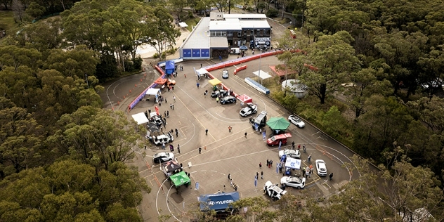 Ariel view of an electrical vehicle drive day with several cars parked in a parking lot.