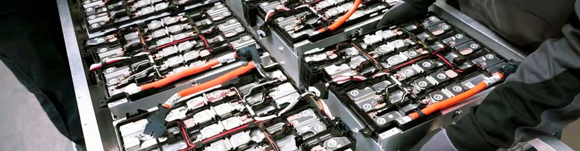 Someone inspecting the inside of an EV battery