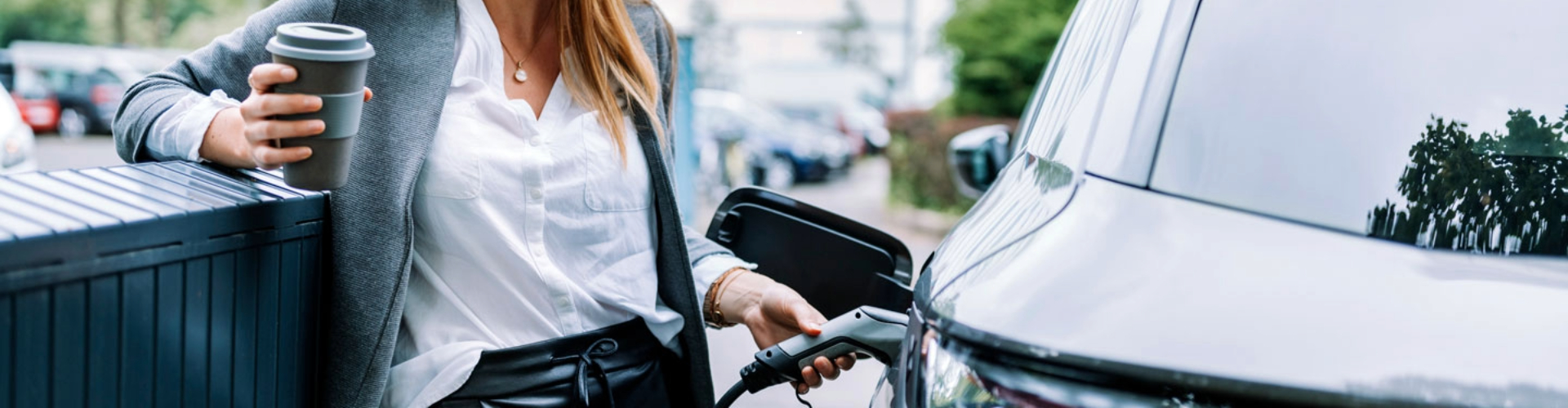 A business person enjoying a coffee while charging their EV
