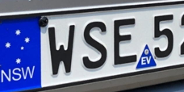 A New South Wales vehicle number plate, with a blue EV safety sticker in the bottom middle of the plate.