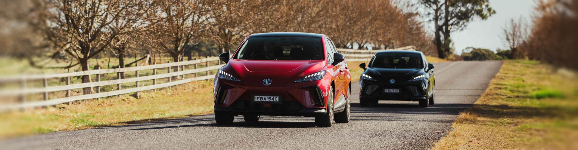 Two MG electric cars driving on a country road