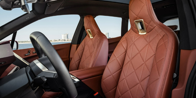 Luxury diamond-stitch pattern front seats and brown leather interior finishes inside the BMW iX.