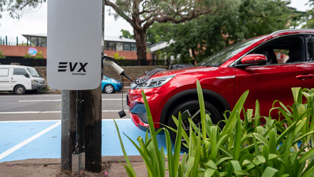 A red EV charging on the street
