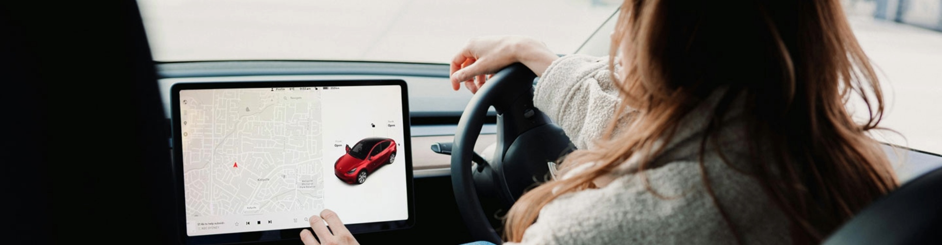 A driver using the touchscreen in their EV