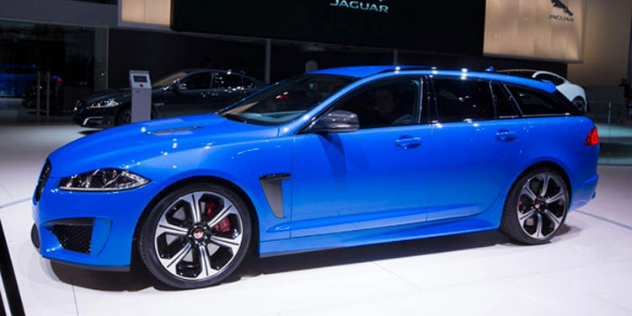 Side view of a blue sedan parked in a brightly lit showroom.