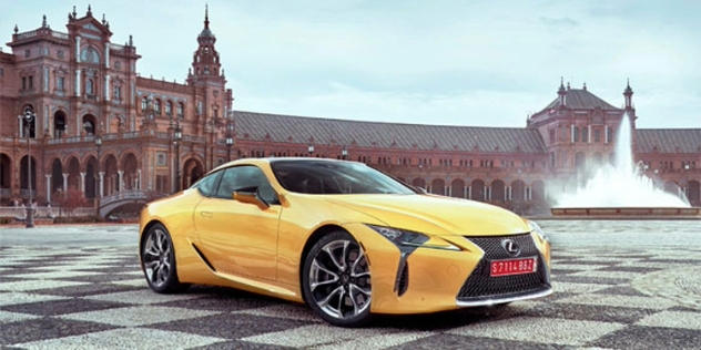 A luxury sedan parked in front of an elaborate brown building.