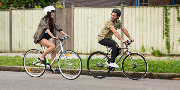 A man and woman cycling along a street