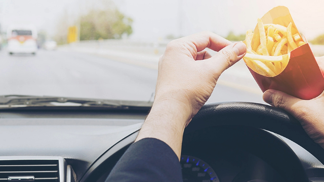 Man eating fries while driving Man eating fries while driving