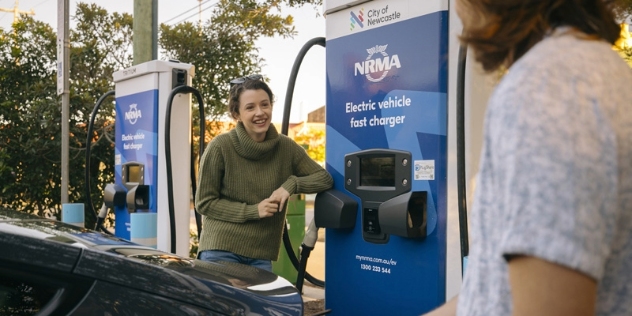 Two women talking while charging their EVs at an NRMA fast charging station